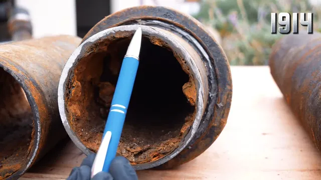 Close view inside an old cast iron drain pipe filled with rust scale and mineral buildup