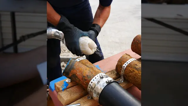 Technician joining an older cast iron drain to a smooth replacement pipe with a shielded coupling