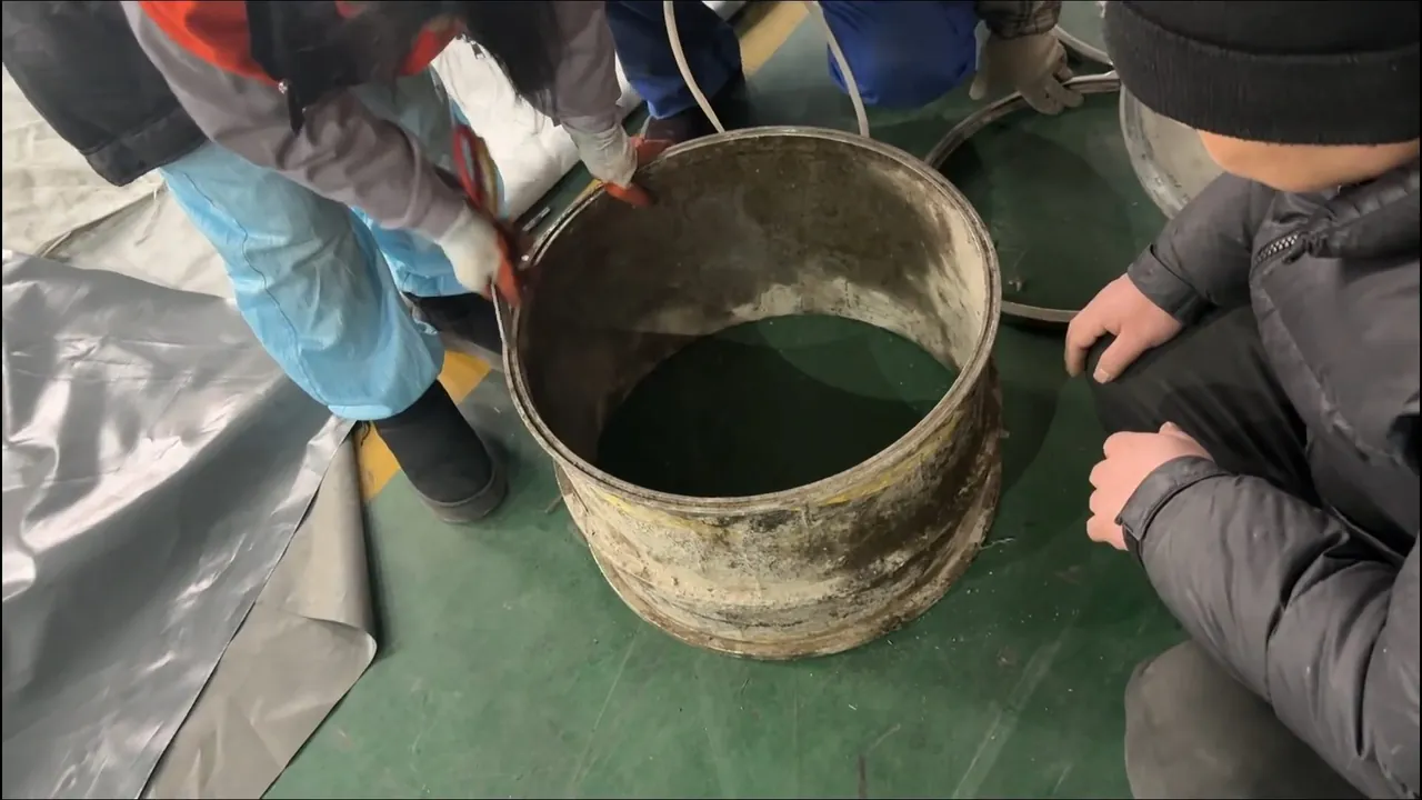 Technicians examining dark wastewater recovered during a drain flushing service
