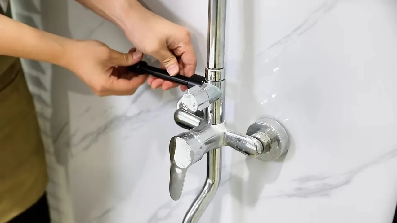 Plumber adjusting the exposed valve on a shower fixture in Edgewater