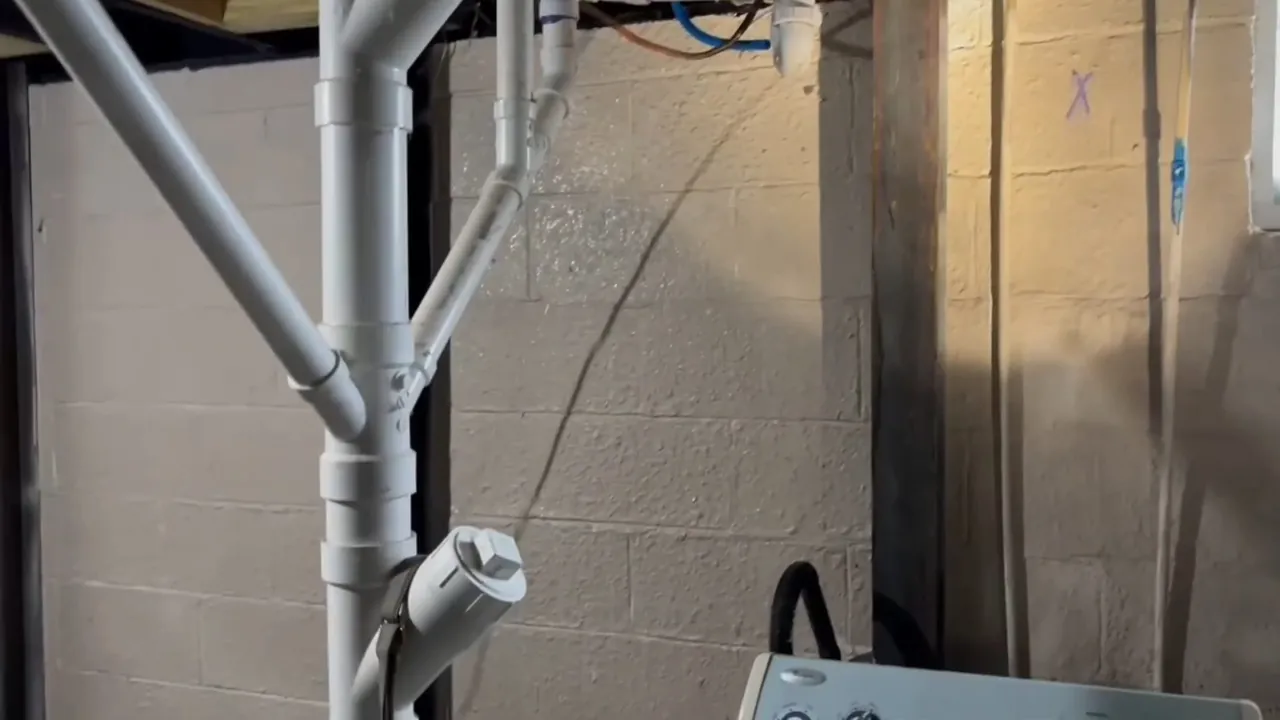 PVC drain and vent piping installed against a basement masonry wall in Fruitdale
