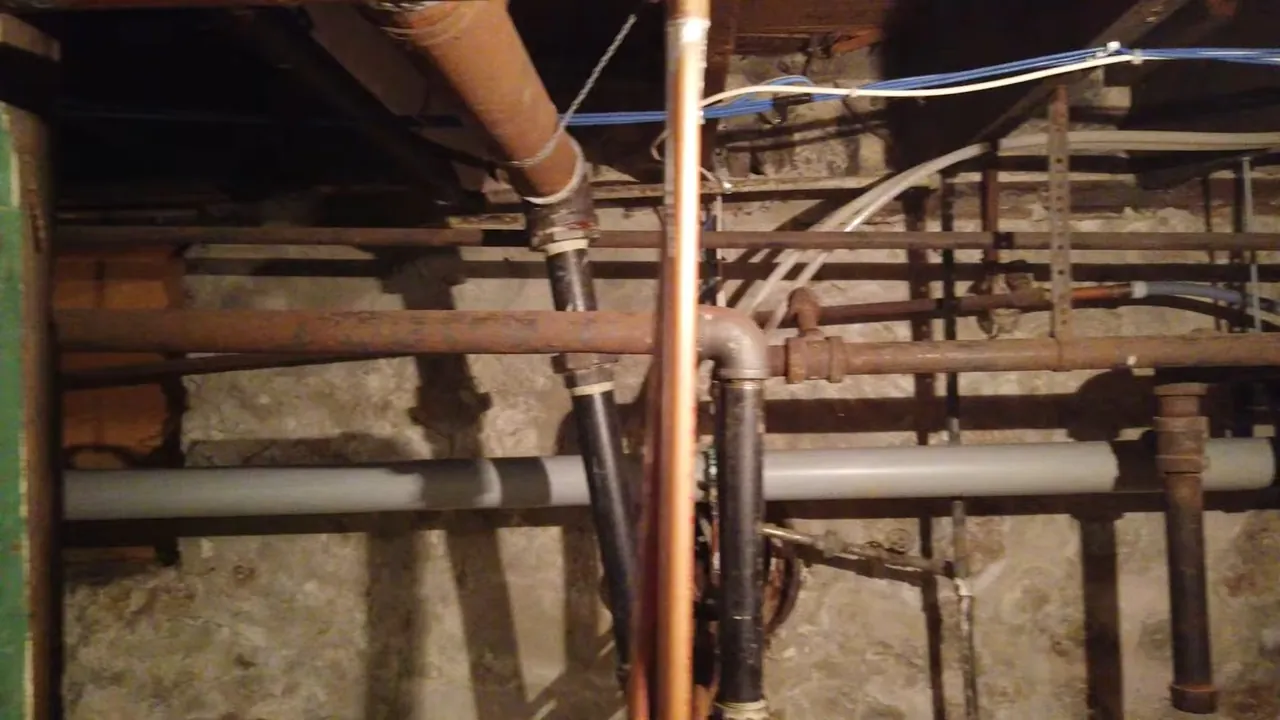 Dense network of older copper and drain piping below a historic home