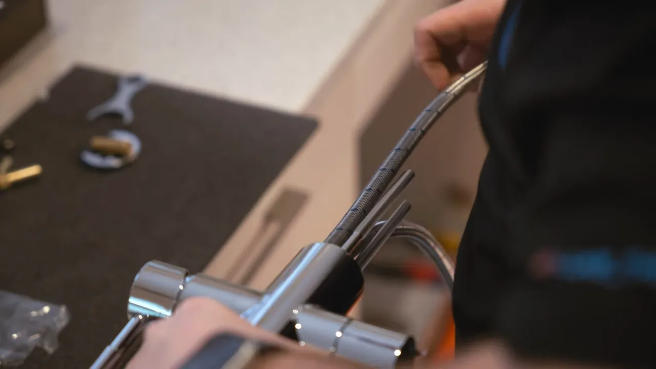 Plumber tightening the connections on a modern kitchen faucet