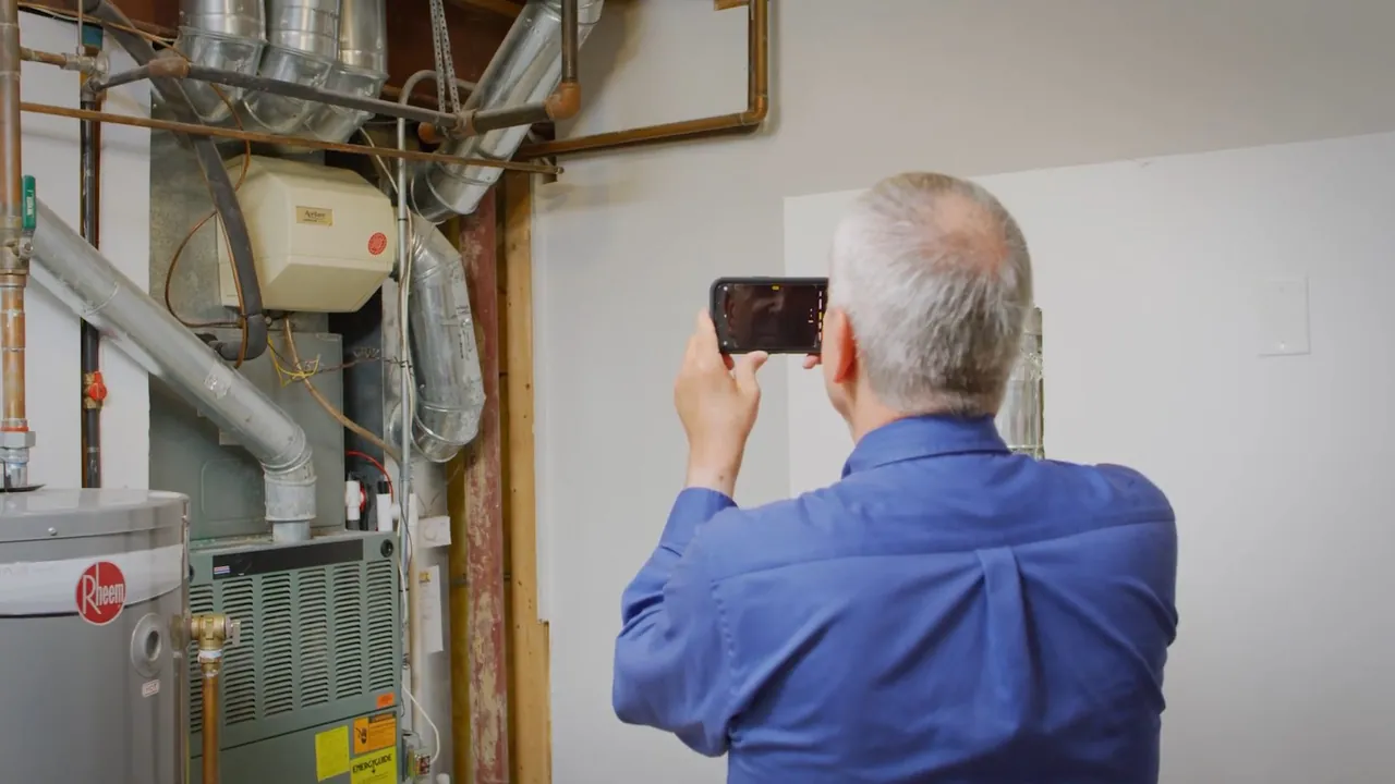 Technician documenting a residential water heater and nearby mechanical equipment in Lakewood