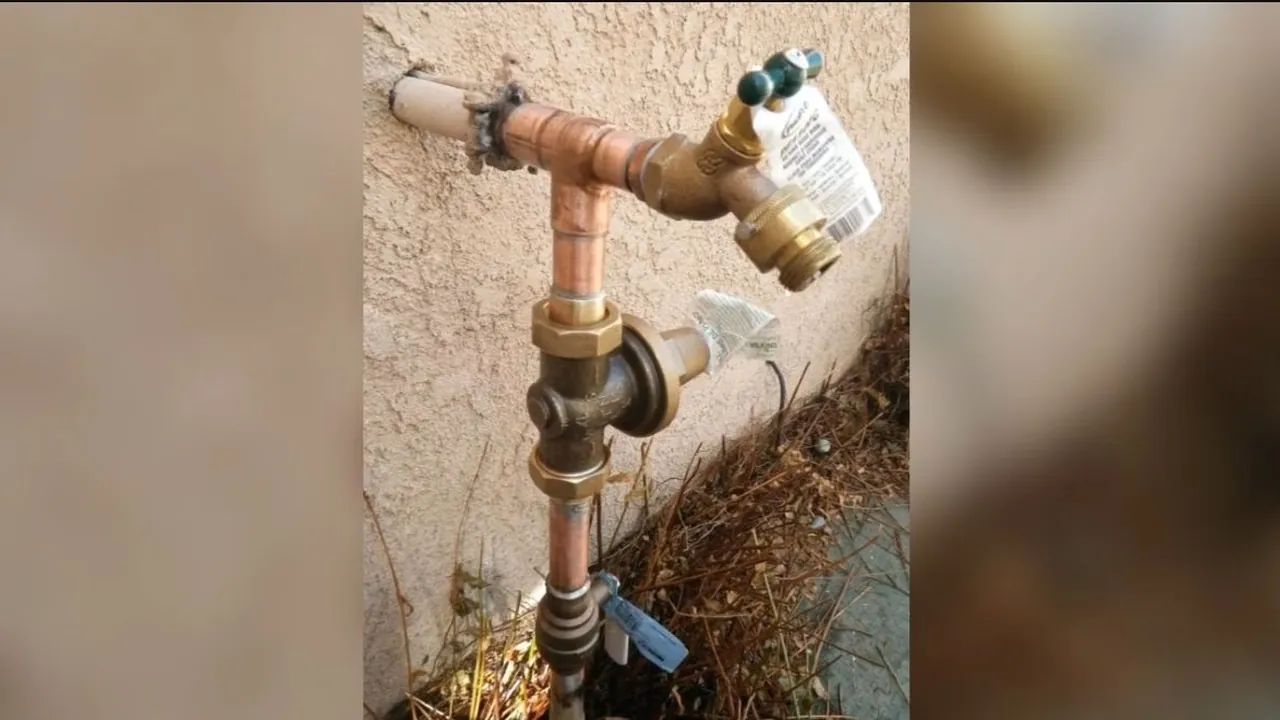 Exterior hose bib fitted with a vacuum breaker on a stucco wall