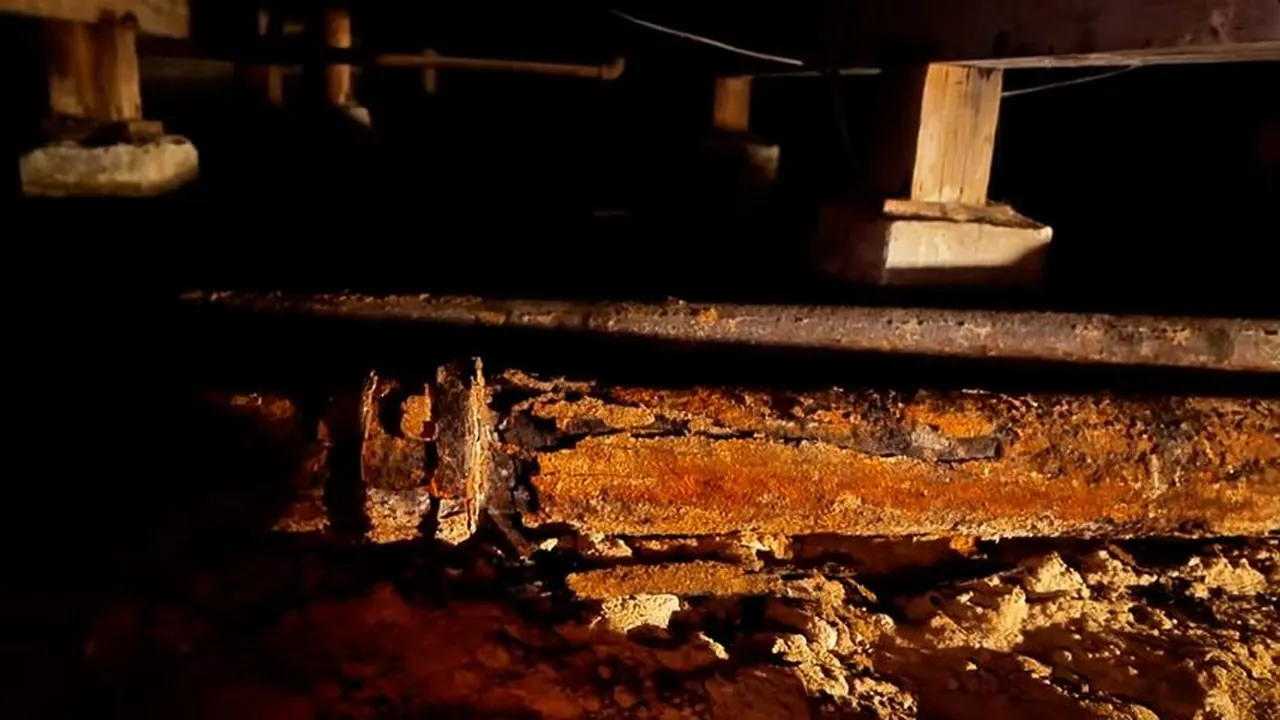 Severely rusted sewer pipe with heavy flaking and an irregular opening