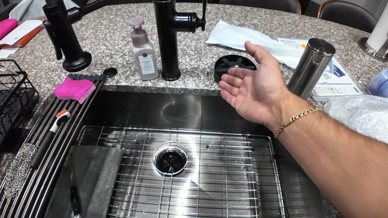 Technician working at a stainless steel kitchen sink and drain opening