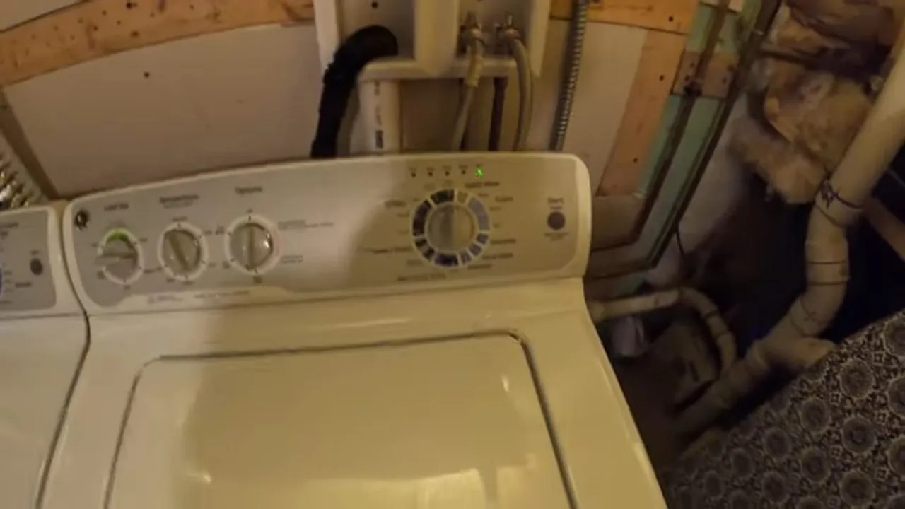 Laundry appliance connections and drain piping behind a washer in Tennyson-Berkley