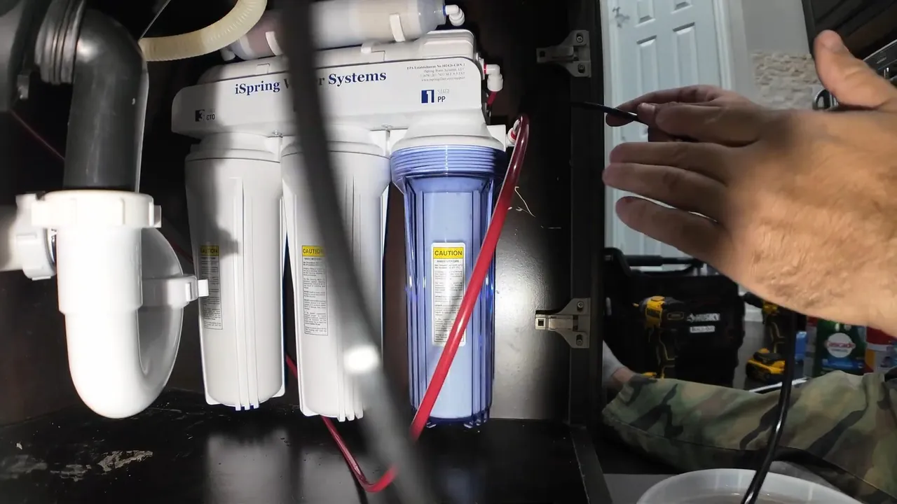 Multi-stage reverse osmosis filtration system mounted below a kitchen sink