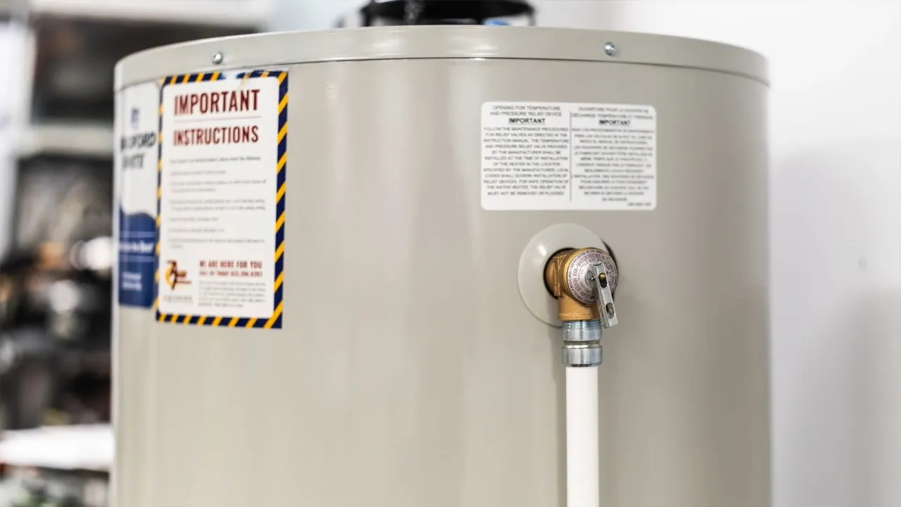 Residential water heater tank with operating and safety labels visible